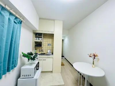 a small white kitchen with a table and a counter at Top Ikebukuro 301 -TS0034 in Tokyo