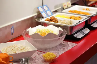 a red counter top with several trays of food at HOTEL Guest1 Ueno Ekimae in Tokyo