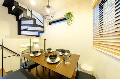 a dining room with a table and chairs and a staircase at Shinjuku-Nakano Residence -\u6771\u4e2d\u91ce\u30de\u30f3\u30b9\u30ea\u30fc\u30cf\u30a6\u30b9 - 3\u968e\u5efa\u3066\u5c4b\u4e0a\u4ed8\u304d\u306e1\u68df\u8cb8\u3057\u5207\u308a - \u6700\u59277\u540d in Tokyo