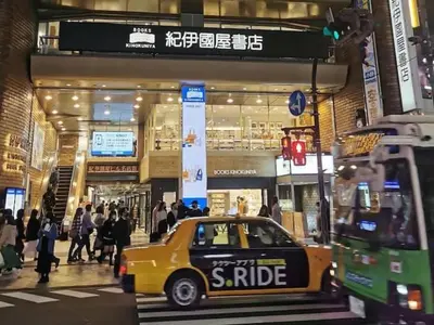 a yellow taxi cab parked in front of a store at Shinjuku\u5bbf in Tokyo
