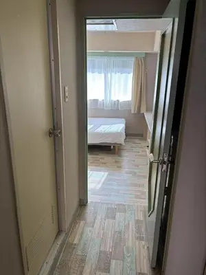 a hallway with a bedroom with a bed and a window at Shinjuku\u5bbf in Tokyo
