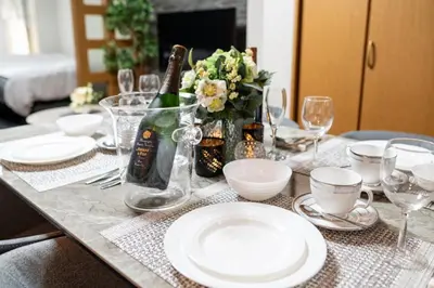 a table with white plates and a bottle of champagne at Za086 \u67cf\u539f\u30d3\u30eb101 in Tokyo