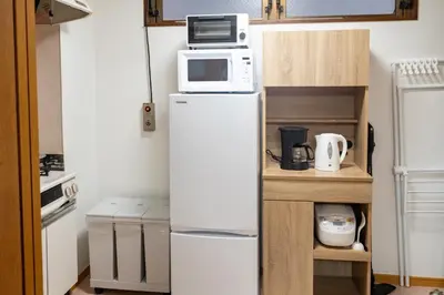 a small kitchen with a refrigerator and a microwave at Za086 \u67cf\u539f\u30d3\u30eb101 in Tokyo