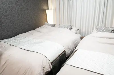 two beds in a hotel room with white sheets at Za086 \u67cf\u539f\u30d3\u30eb101 in Tokyo