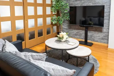 a living room with a couch and tables and a tv at Za086 \u67cf\u539f\u30d3\u30eb101 in Tokyo