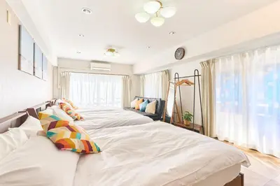 a bedroom with two beds with white sheets at B-Shinjuku luxury house with EV Max12P in Tokyo
