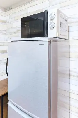 a microwave sitting on top of a refrigerator at B-Shinjuku luxury house with EV Max12P in Tokyo