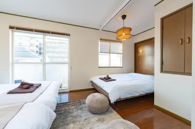 a bedroom with two beds and a couch at Vivere in Tokyo