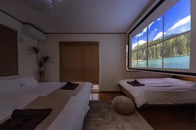 two beds in a room with a large window at Vivere in Tokyo