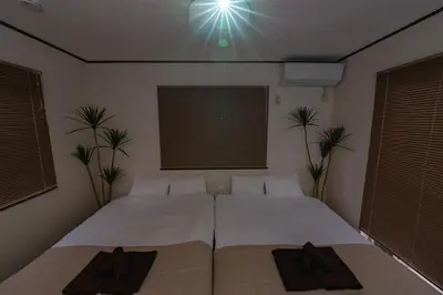 a room with two beds in a room with plants at Vivere in Tokyo