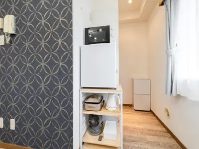 a small refrigerator in a room with a wall at Omotesando Sta 8min walk,Shibuya,Harajuku 3min,10GB net, PocketWiFi, Switch in Tokyo