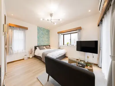 a bedroom with a bed and a couch and a tv at Omotesando Sta 8min walk,Shibuya,Harajuku 3min,10GB net, PocketWiFi, Switch in Tokyo