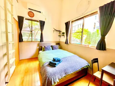 a bedroom with a bed and two windows at Vonveil Shibuya in Tokyo