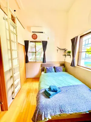 a bedroom with a bed with a blue blanket at Vonveil Shibuya in Tokyo