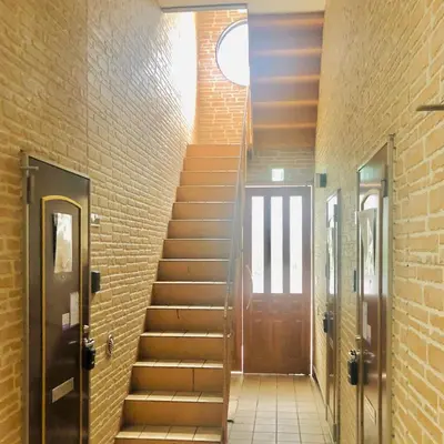 a staircase in a building with a wooden door at Vonveil Shibuya in Tokyo