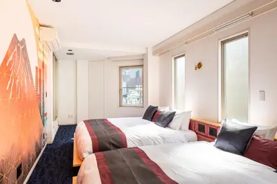 two beds in a room with two windows at NEXUS HOTEL Gotanda WEST in Tokyo