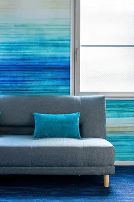 a couch with a blue pillow in a room at NEXUS HOTEL Gotanda WEST in Tokyo
