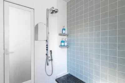 a bathroom with a shower with blue tiles at NEXUS HOTEL Gotanda WEST in Tokyo