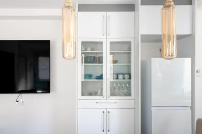 a kitchen with white cabinets and a refrigerator at NEXUS HOTEL Gotanda WEST in Tokyo