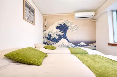 a bedroom with a wave mural on the wall at Monthly Stay Furnished Apartment \u6c60\u888b\u99c5\u5f92\u6b69 5\u5206 Mejiro Yasu Hotel in Tokyo