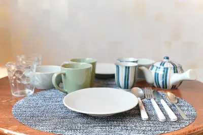a table with a plate and some cups and utensils at Monthly Stay Furnished Apartment \u6c60\u888b\u99c5\u5f92\u6b69 5\u5206 Mejiro Yasu Hotel in Tokyo