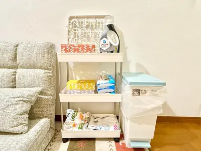 a shelf with food and a bottle of wine next to a couch at \u9ad8\u7530\u99ac\u5834 4\u4eba\u53efa2 in Tokyo