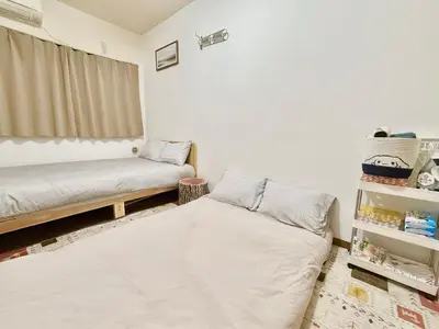a small bedroom with two beds and a window at \u9ad8\u7530\u99ac\u5834 4\u4eba\u53efa2 in Tokyo