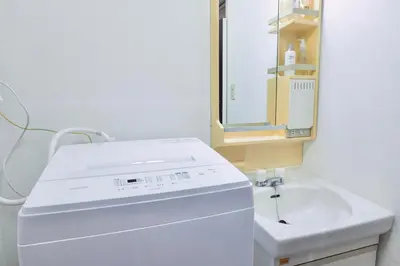a white bathroom with a sink and a mirror at \u30b6\u30eb\u30c4\u66f3\u821f in Tokyo