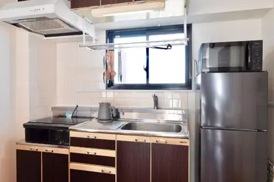 a kitchen with a sink and a stainless steel refrigerator at \u30b6\u30eb\u30c4\u66f3\u821f in Tokyo