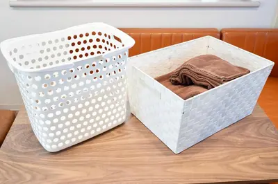 a white laundry basket sitting on a wooden table at \u30b6\u30eb\u30c4\u66f3\u821f in Tokyo