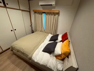a small bedroom with a bed with colorful pillows at Nakai House!! Tokyo Home near Shinjuku - Groups & Families in Tokyo