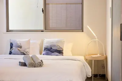 a bedroom with a white bed with towels on it at \u5bbf\u6816\u4e21\u56fd in Tokyo