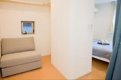 a bedroom with a bed and a chair in it at \u5bbf\u6816\u4e21\u56fd in Tokyo