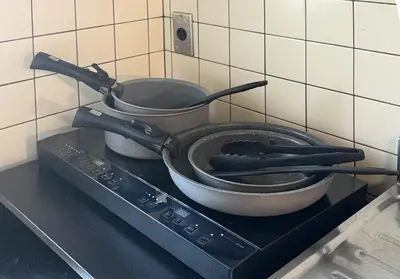 a pan sitting on top of a stove with utensils at \u6771\u771f\u30d3\u30eb3f in Tokyo