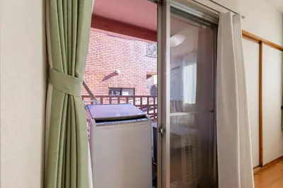 a sliding glass door to a patio with a heater at \u6771\u771f\u30d3\u30eb3f in Tokyo