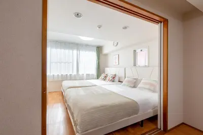 a bedroom with a large mirror reflecting a bed at \u6771\u771f\u30d3\u30eb3f in Tokyo