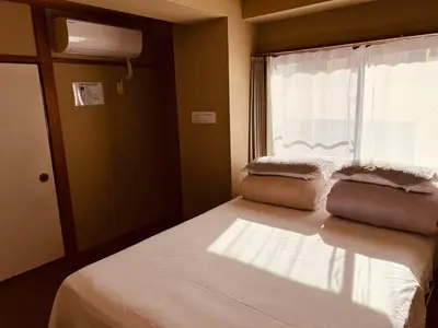 a bedroom with a large bed with a window at Skytree Residence \u9326\u7cf8\u753a \u99c5\u304b\u3089600M\u5f92\u6b698\u5206 in Tokyo
