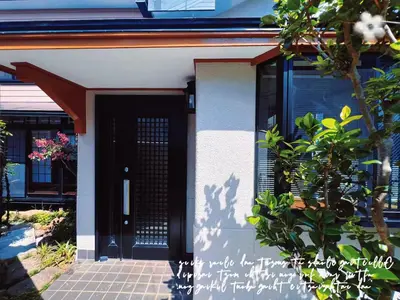 a house with a black door and a plant at Charming Japanese Villa with Quiet, Private Garden in Tokyo