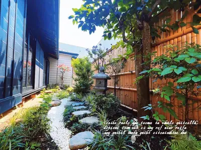 a garden with a bird bath next to a fence at Charming Japanese Villa with Quiet, Private Garden in Tokyo