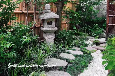 a stone bird bath in a garden with rocks at Charming Japanese Villa with Quiet, Private Garden in Tokyo
