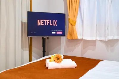 a tv and a towel on a bed with a television at O-JR \u9ad8\u7530\u99ac\u5834 5mins walk Guest House! New open! Wi-fi! Shinjyuku Waseda area in Tokyo