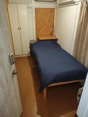 a small room with a bed with a blue sheet at 130Ｍ2 Entire House Max 12 Guests Entire House 5 min to Ikebukuro Perfect for Groups & Families in Tokyo