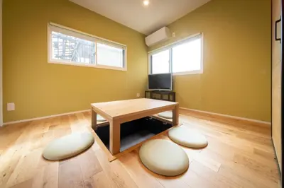 a living room with a table and a tv at NOIL 2 \u6c60\u888b Ikebukuro \u6c60\u888b\u99c5\u5f92\u6b6914\u5206 \u690e\u540d\u753a\u99c5\u5f92\u6b695\u5206 in Tokyo