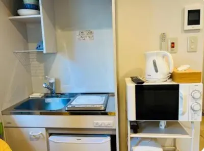 a small kitchen with a sink and a microwave at ShinjukuLion in Tokyo