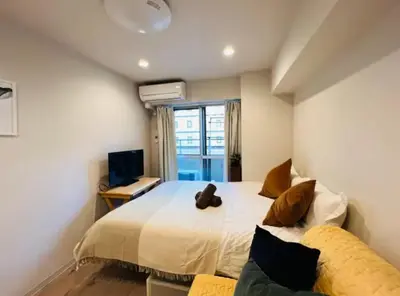 a bedroom with a large bed and a television at ShinjukuLion in Tokyo