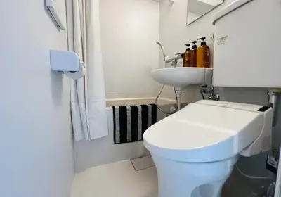 a bathroom with a white toilet and a sink at ShinjukuLion in Tokyo
