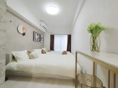 a bedroom with a white bed and a vase of flowers at G35\u65b0\u5bbf\u6700\u4e2d\u5fc3 \u6771\u65b0\u5bbf\u7ad95\u5206-Shinjuku center 5 mins to st, Max 4P \u65b0\u5bbf \u6d89\u8c37 \u8868\u53c2\u9053 \u6c60\u888b \u4e0a\u91ce \u4ee3\u4ee3\u6728 \u94f6\u5ea7 \u539f\u5bbf in Tokyo