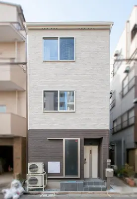 a tall building with a door and two windows at \u745e\u306e\u5bbf\u6d45\u8349 in Tokyo