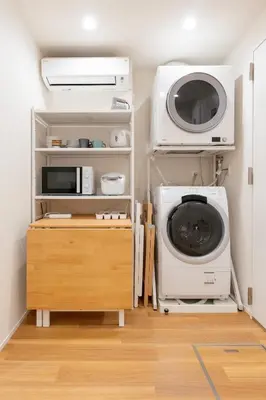 a laundry room with a washing machine and a microwave at \u745e\u306e\u5bbf\u6d45\u8349 in Tokyo