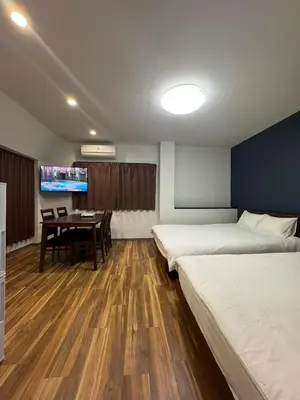 a room with two beds and a table and a tv at \u548c\u306e\u6953cottage\u7b2c\u4e8c301 \u65b0\u5bbf\u6b4c\u821e\u4f0e\u753a\u8fd1\u96a3 in Tokyo
